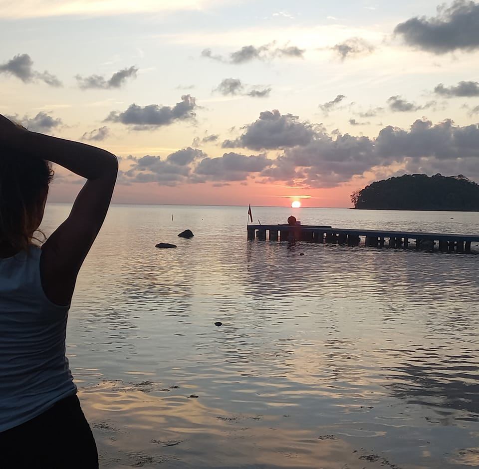 photo de ta Travel Planner de Dos, face à un couché de soleil sur la mer